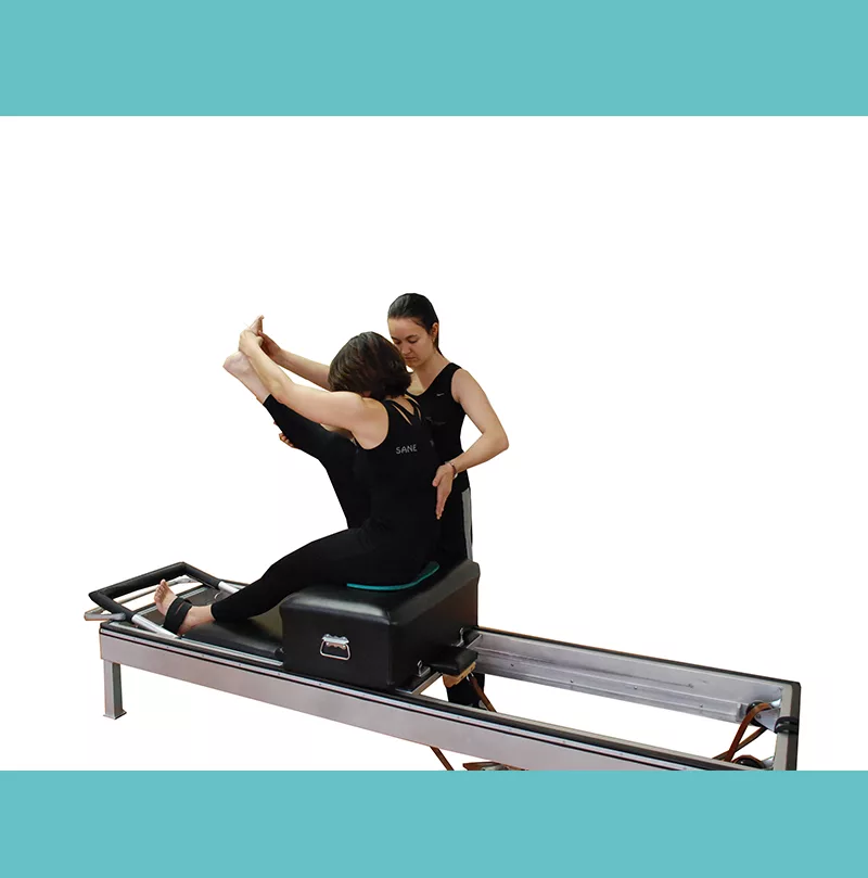 instructora-de-sane-fisio-y-pilates-en-madrid-guiando-a-alumna-en-maquina-reformer--favoreciendo-la-conciencia-del-movimiento-y-la-correccion-postural