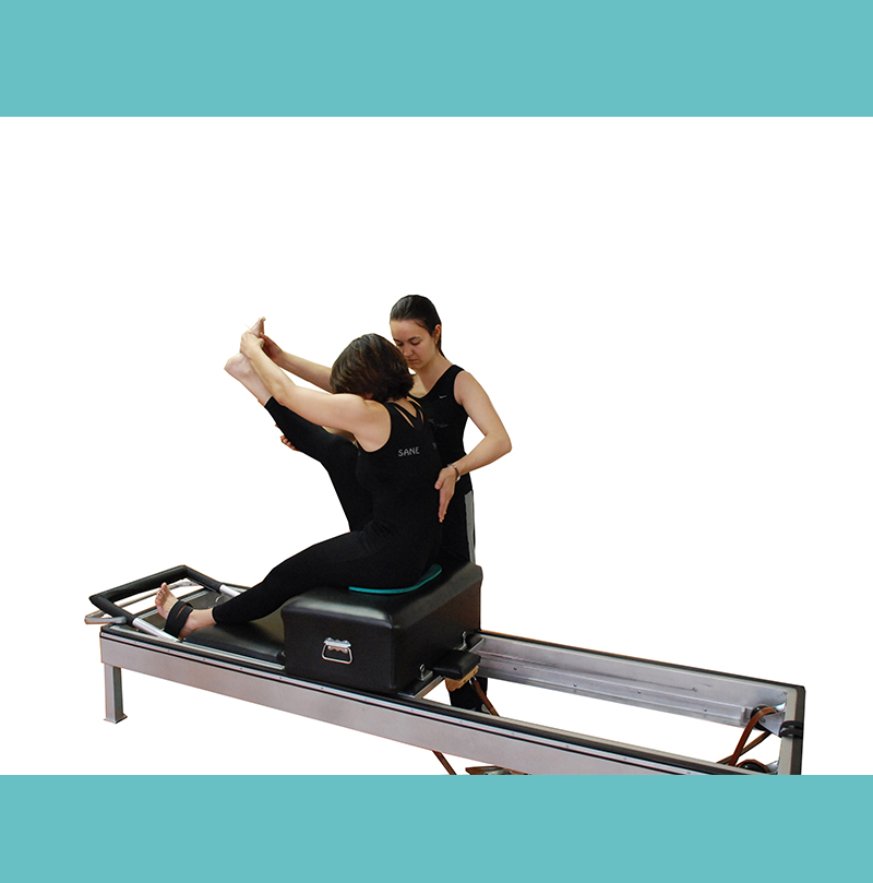 instructora-de-sane-fisio-y-pilates-en-madrid-guiando-a-alumna-en-maquina-reformer--favoreciendo-la-conciencia-del-movimiento-y-la-correccion-postural